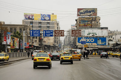 Traffic on city street against sky