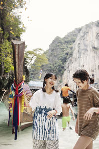 Smiling female tourists standing in river in canyon