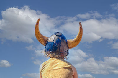 Rear view of person wearing hat against sky