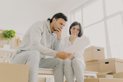 Couple sitting on table in room