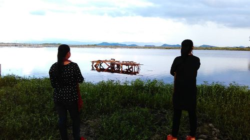 Silhouette of people looking at sea