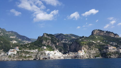 Scenic view of sea by buildings against sky