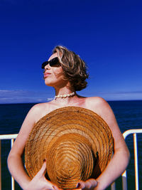 Midsection of woman wearing sunglasses against sky