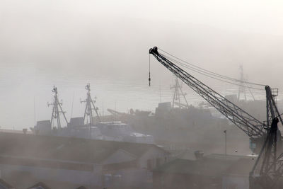 Cranes at construction site against sky