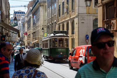 People on street against buildings in city