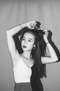 Portrait of young woman against gray background