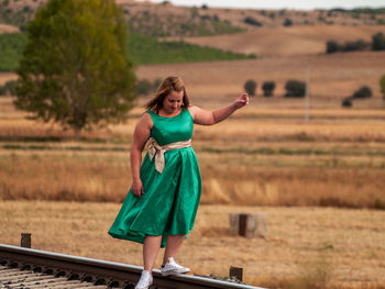 Woman standing on railroad tracks