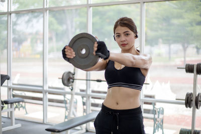 Portrait of woman standing exercising in gym