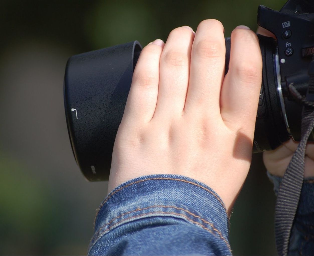 human body part, one person, real people, hand, body part, technology, human hand, photography themes, camera - photographic equipment, close-up, holding, day, women, communication, lifestyles, focus on foreground, camera, unrecognizable person, leisure activity, outdoors, digital camera, jeans, finger