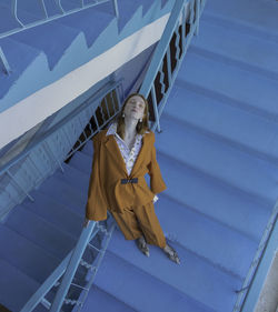 High angle view of teenage girl with eyes closed standing on steps