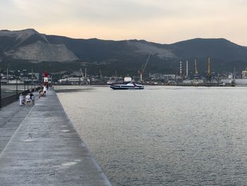 Scenic view of sea by mountains against sky