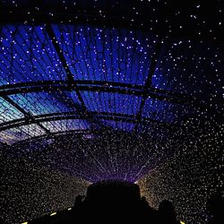 Low angle view of illuminated building against sky at night