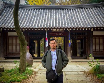 Portrait of smiling man standing against building