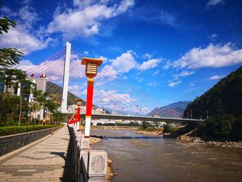 Bridge over river in city against sky