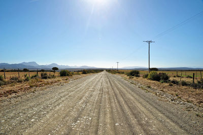 Road by land against sky on sunny day