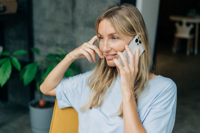 Young woman looking away and using mobile phone