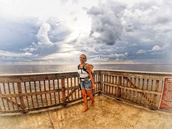 Full length of woman standing on beach against sky