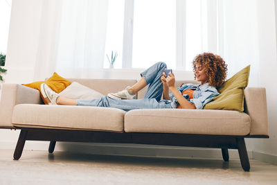 Portrait of woman sitting on sofa at home