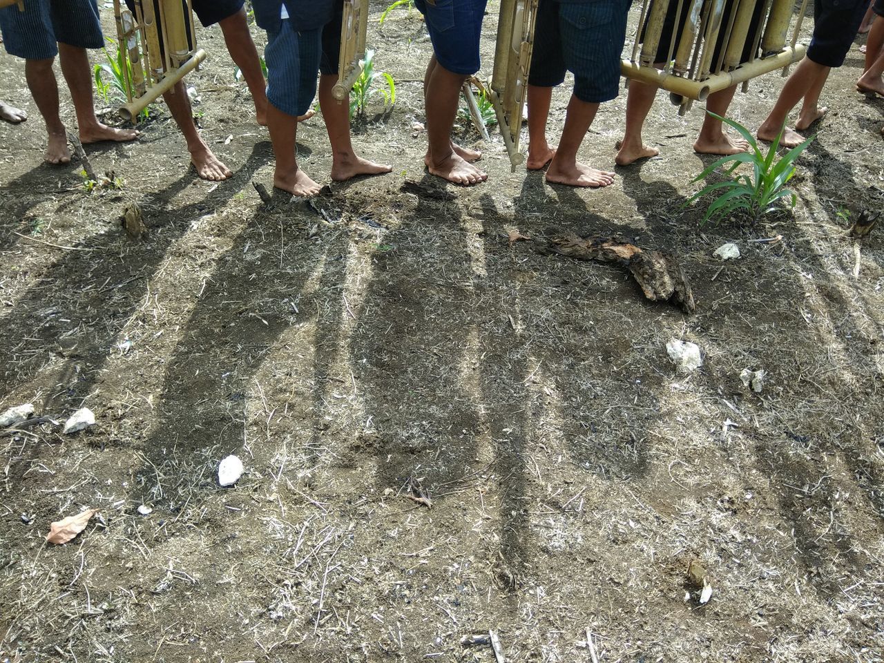 LOW SECTION OF PEOPLE STANDING ON COBBLESTONE