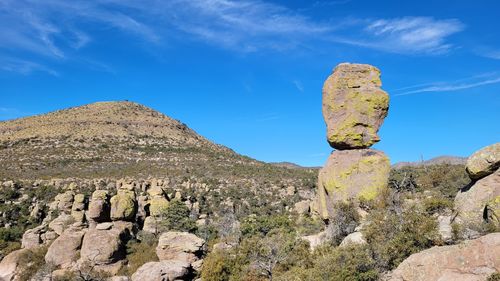 Rock formations on landscape against blue sky