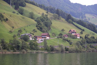 Scenic view of trees and houses by mountains