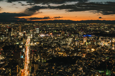 High angle view of illuminated cityscape against sky at night