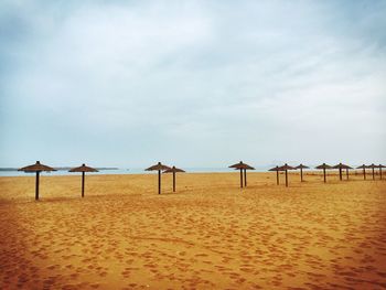 Sunshades on beach against sky