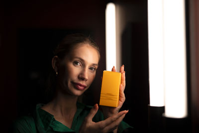 Midsection of woman holding lit candle