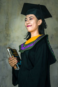 Portrait of a smiling young woman holding smart phone