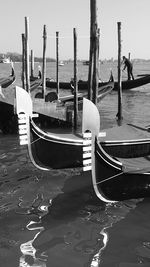 Boats moored on wooden post by sea