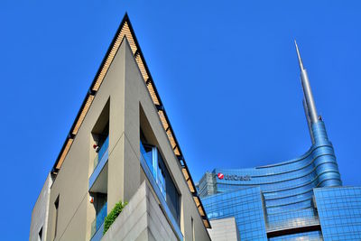 Low angle view of modern building against clear blue sky