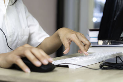 Midsection of woman using laptop on table