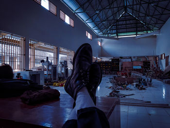 Low angle view of woman standing on illuminated ceiling