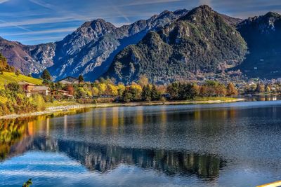 Scenic view of lake and mountains against blue sky