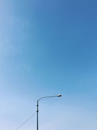 Low angle view of windmill against clear blue sky