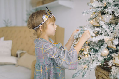 Rear view of girl looking at christmas tree