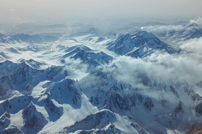 Aerial view of snowcapped mountains against sky