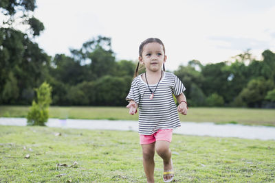 Portrait of young woman standing on field