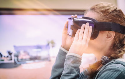 Mid adult woman using virtual reality at home