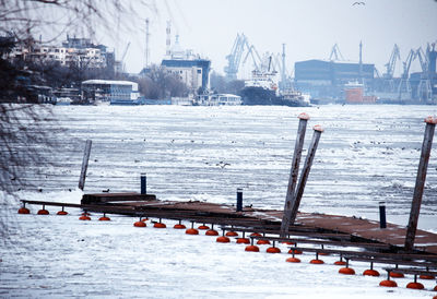 View of frozen river in city during winter