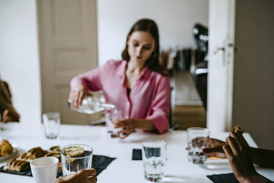 Midsection of woman sitting at table