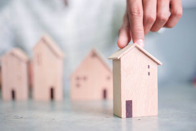 Close-up of hand holding house against building