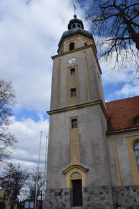 Low angle view of clock tower amidst buildings against sky