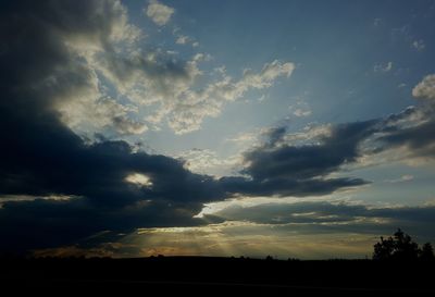 Silhouette of trees against cloudy sky