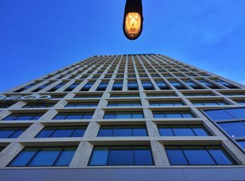 Low angle view of modern building against blue sky