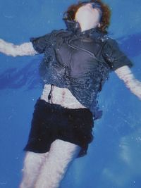 Rear view of woman swimming in pool