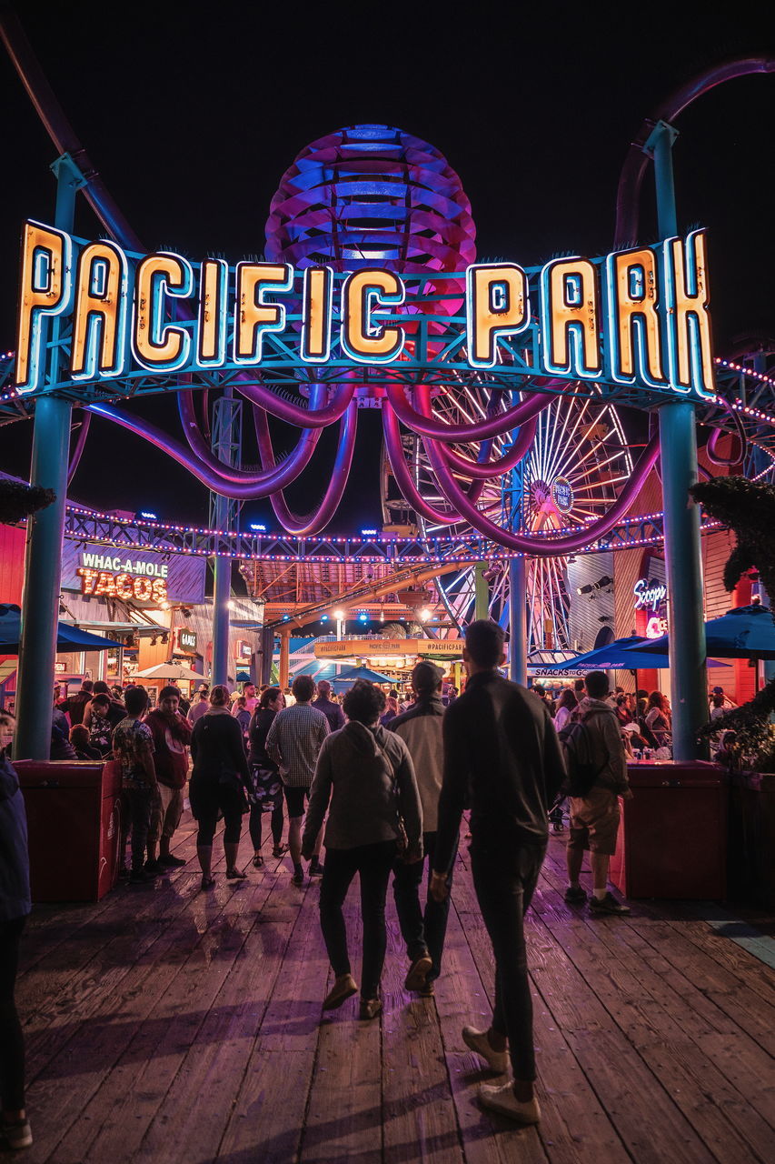 night, illuminated, group of people, real people, men, city, women, communication, text, lifestyles, architecture, adult, leisure activity, people, western script, city life, crowd, built structure, neon, outdoors