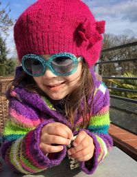 Close-up of smiling girl wearing warm clothing and sunglasses