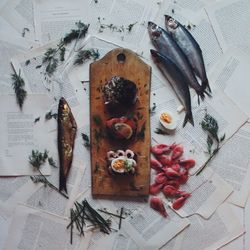 High angle view of fish over papers on table