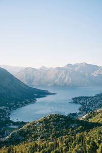 Scenic view of sea and mountains against clear sky